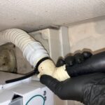 日立のドラム式洗濯機：排水詰まりの原因をバキュームで清掃する